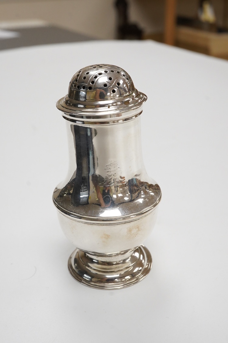 An early George II silver baluster pepperette, maker T?, London, 1734, with engraved crests, height 91mm, 82 grams.